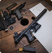 Firearms and accessories laid out on a workbench