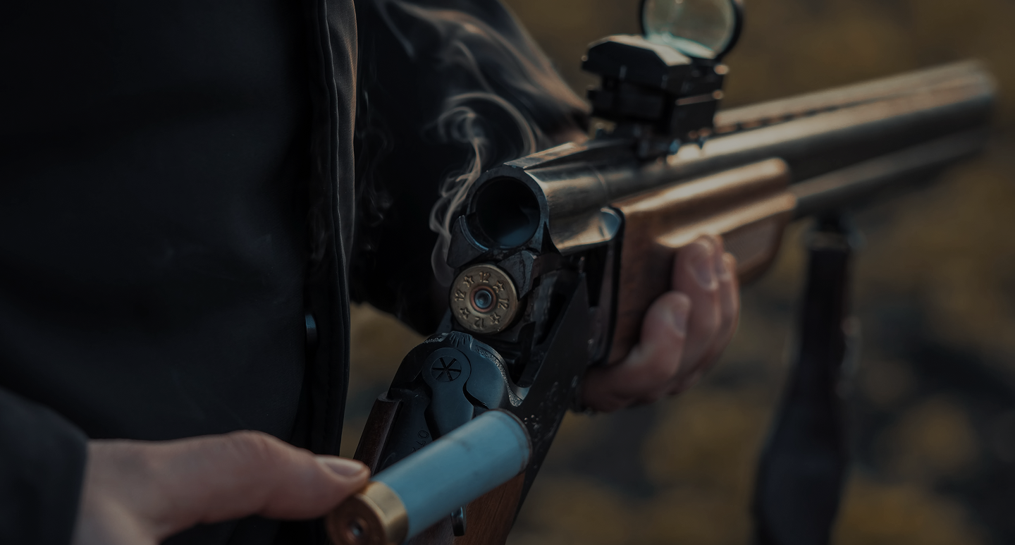 Hunter aiming a shotgun outdoors